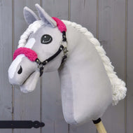 Szürke plüss Hobby Horse ló fehér hókával és fonott sörénnyel, rajta a fekete kötőfék göndör élénk rózsaszín szőrmével