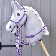 Szürke plüss Hobby Horse ló fehér hókával és fonott sörénnyel, rajta a Start Purple szett lila kötőféke és kötél kantárszára