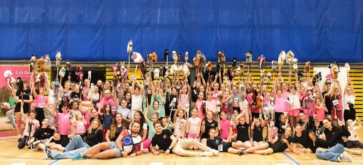 Hobby Horsing résztvevők csoportja Hobby Horse lovakkal a 2026-os LarDen versenyen