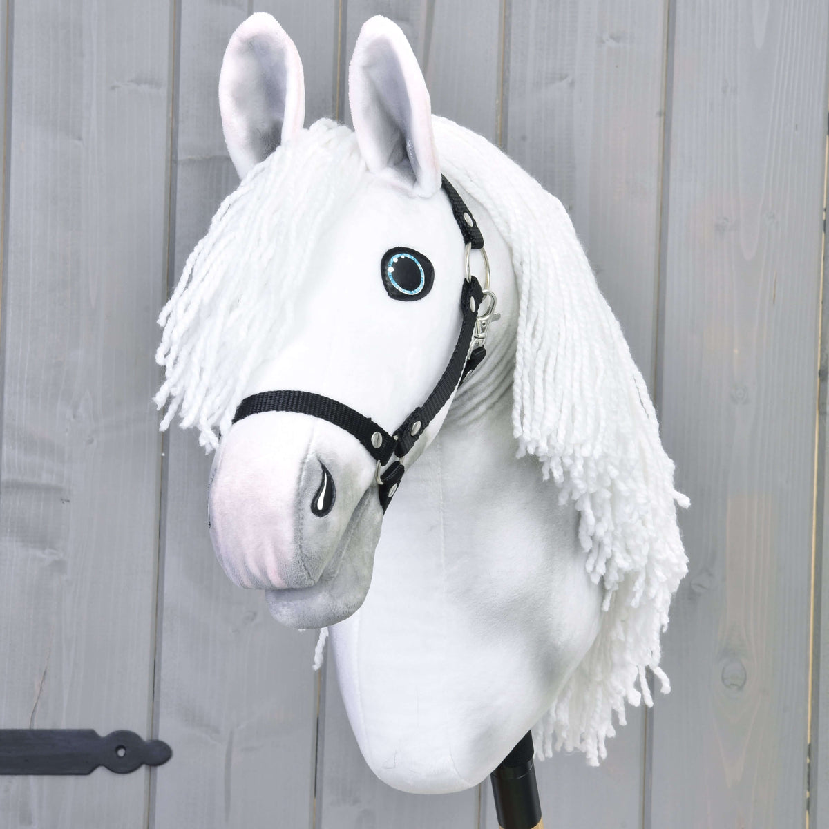 Hobby Horse Elektra fekete kötőfékkel elölről, a hosszú fehér fonalsörény a fej mindkét oldalára omlik