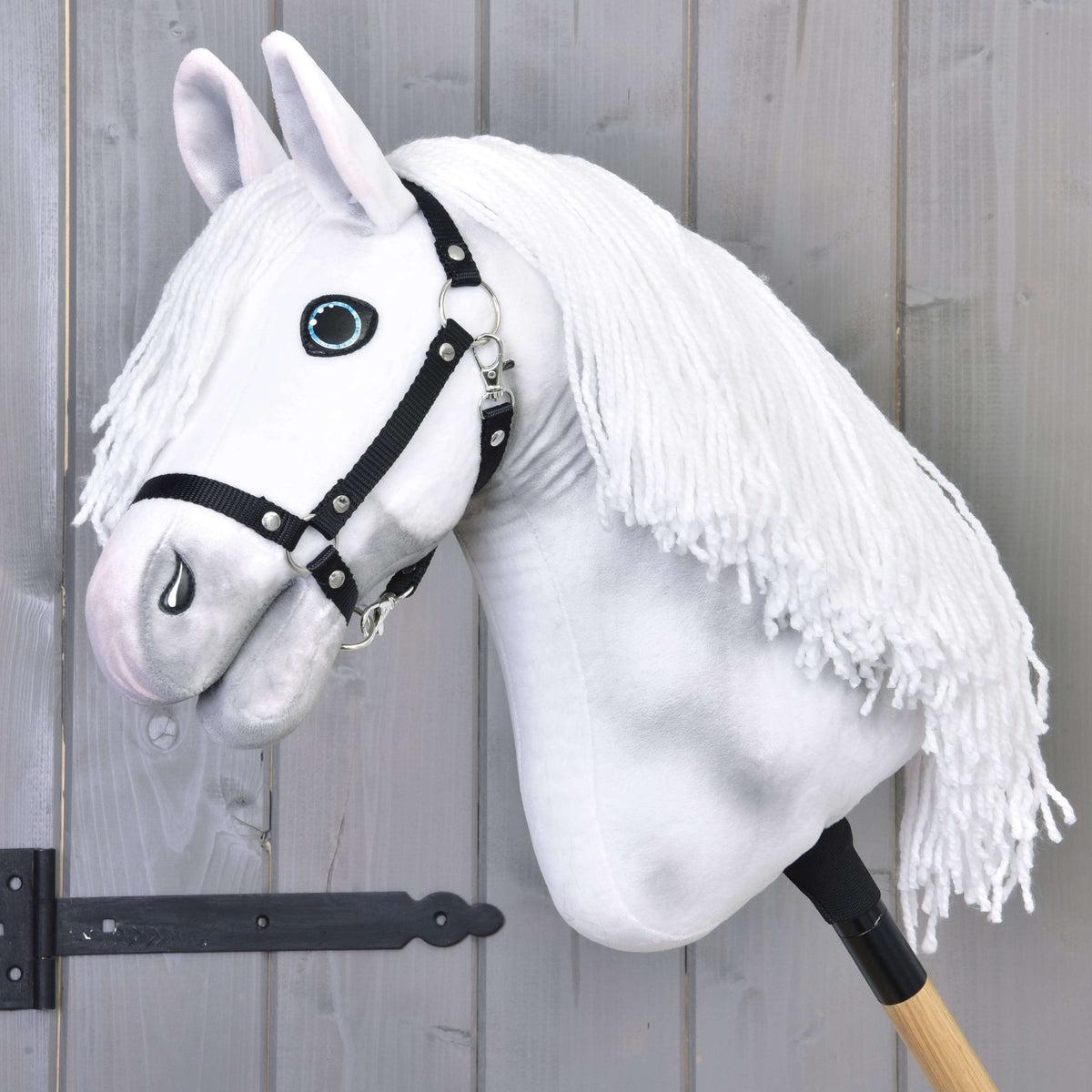 Hobby Horse Elektra fekete kötőfékkel a LarDen kollekciójából: fehér plüssfej szürke árnyalással, kék szemekkel és hosszú fehér fonalsörénnyel