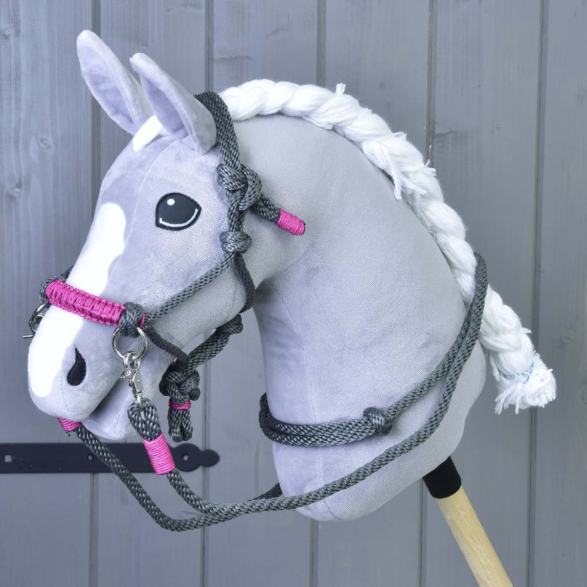 Fonott fehér sörényű szürke Hobby Horse ló a szürke csomózott kötőfékben rózsaszín orrszíjjal és szürke kötél kantárszárral