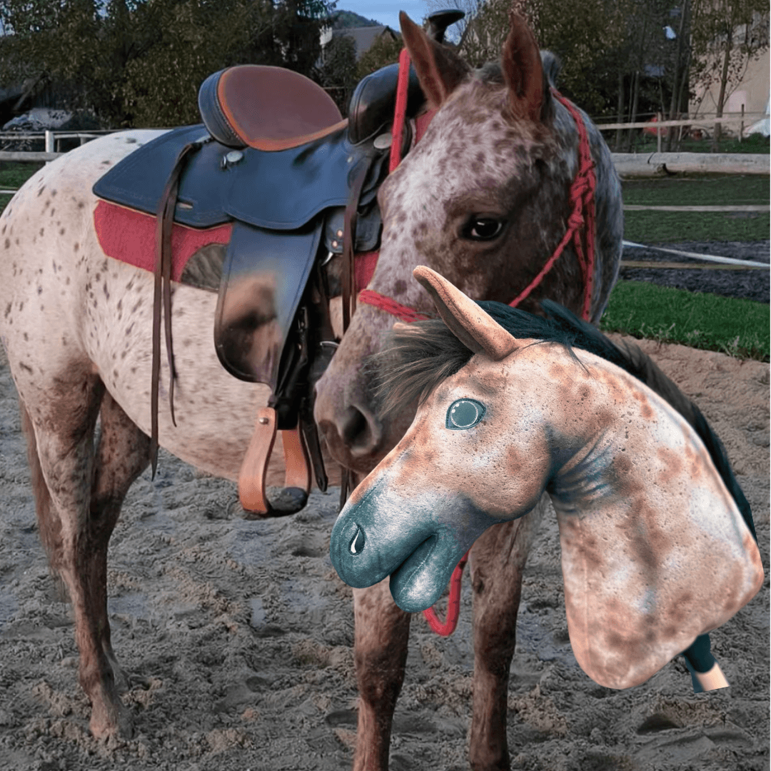 Foltos ló piros csomózott kötőfékben egy homokos pályán, előtte a pettyes, sötét sörényű Hobby Horse másolata