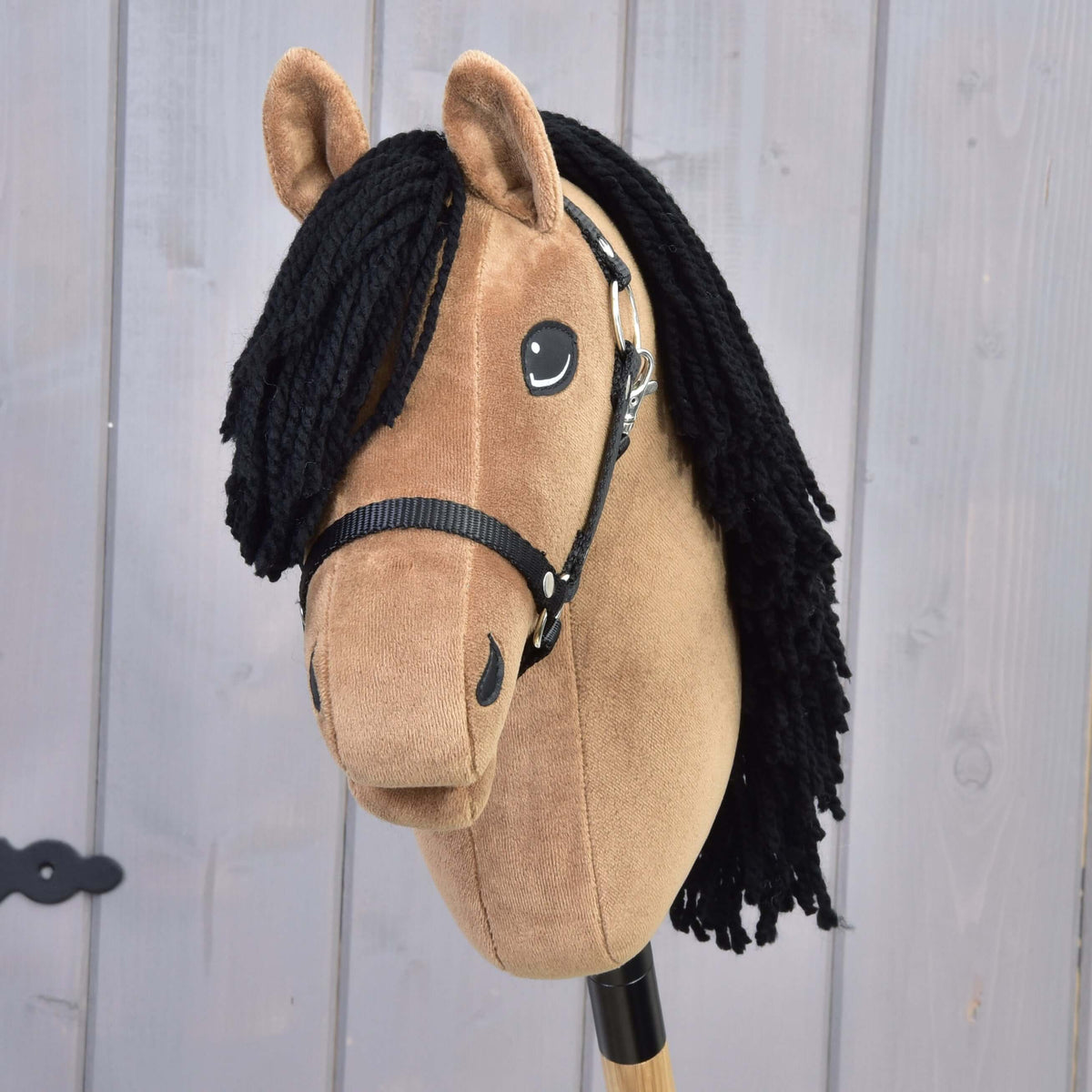 Three-quarter front view of Hobby Horse Samantha with black yarn forelock, smiling eye and black halter