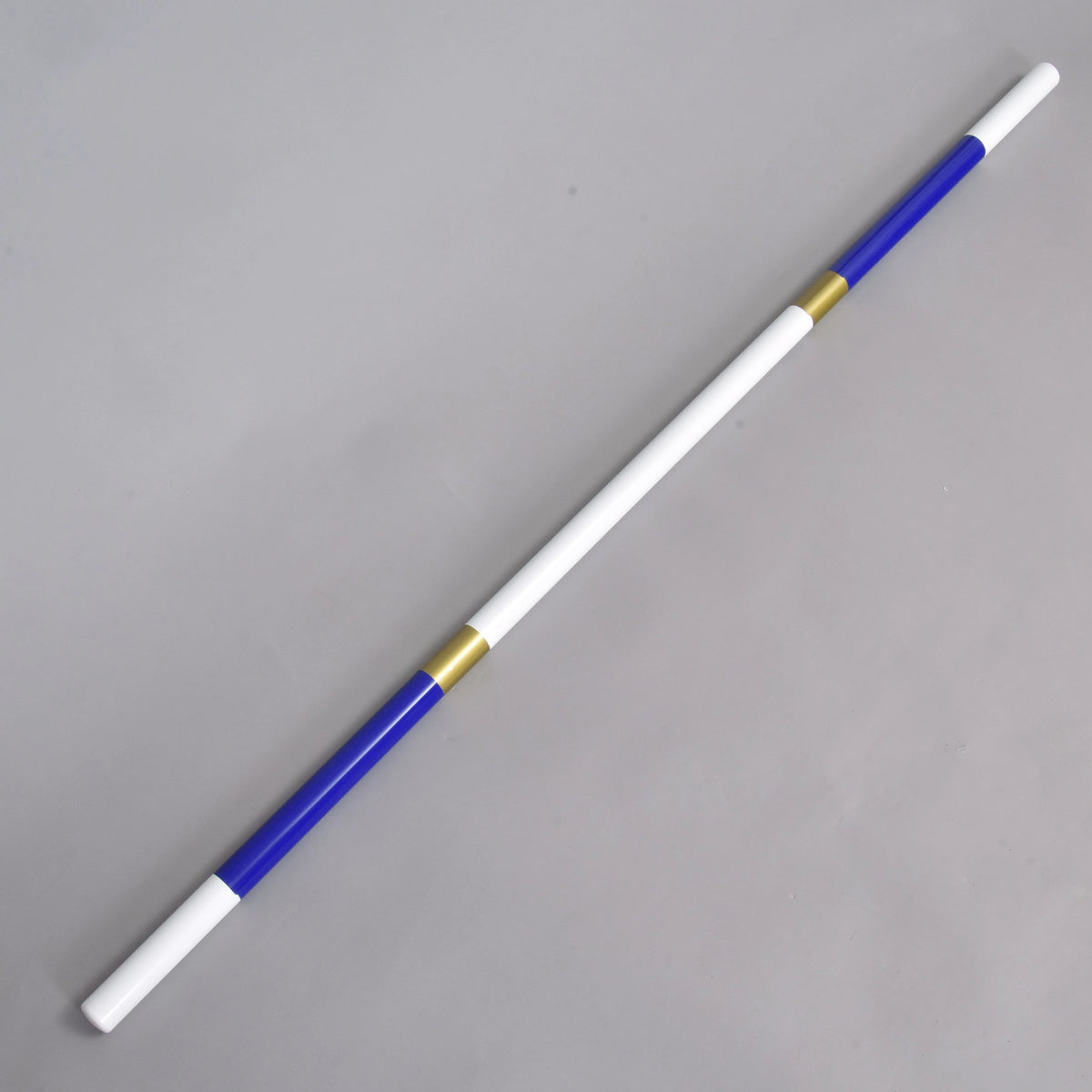 LarDen Hobby Horse akadályrúd kék-arany, fehér végekkel, királykék szakaszokkal és arany sávokkal, szürke padlón fekve