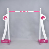 LarDen Hobby Horse Puissance akadály magas, ívelt fehér szárnyakkal, rózsaszín lófejlogókkal, rózsaszín talpakkal és rózsaszín-fehér felső akadályrúddal