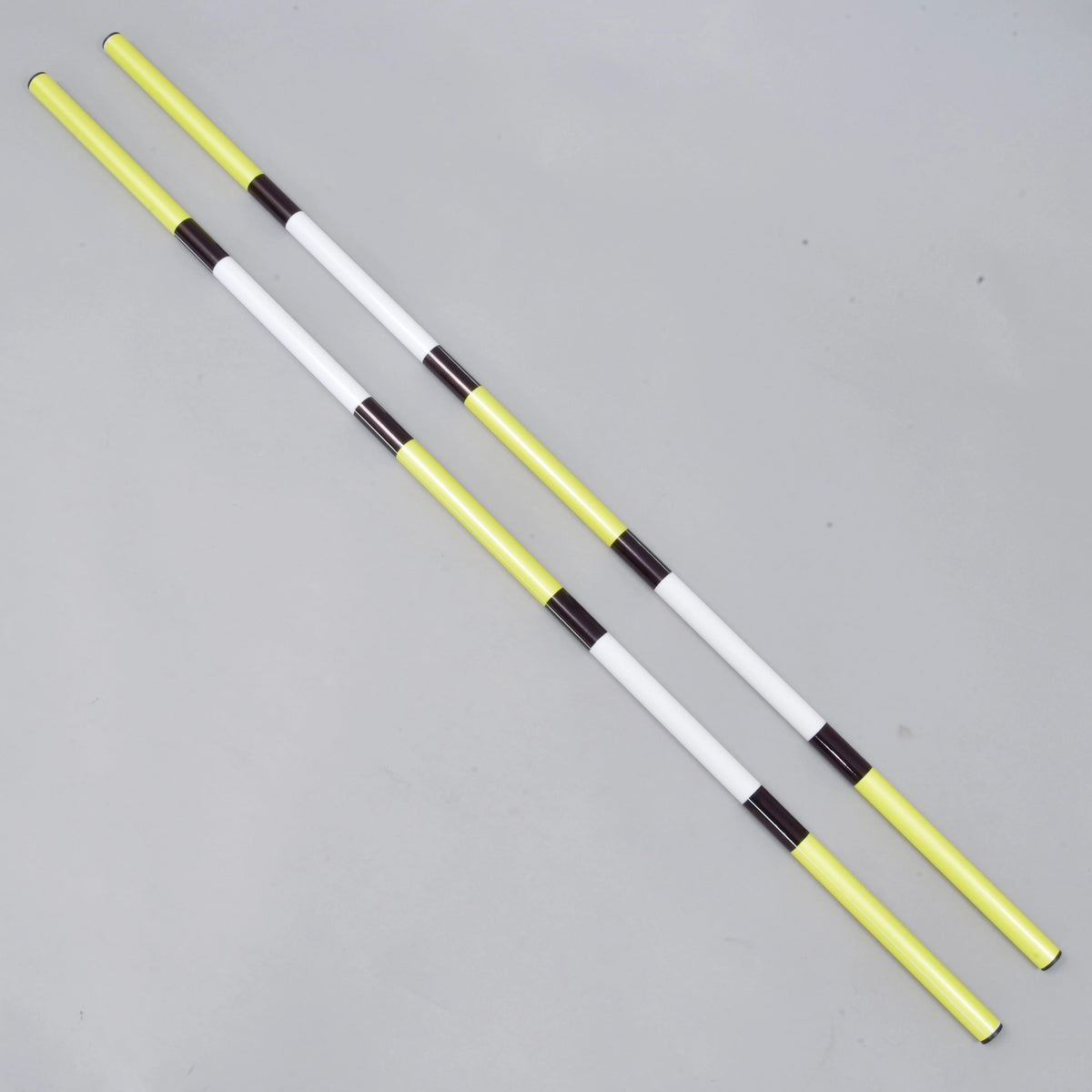 LarDen Hobby Horse Jump pole yellow-black, 2 pcs: two yellow and white poles with black bands lying side by side