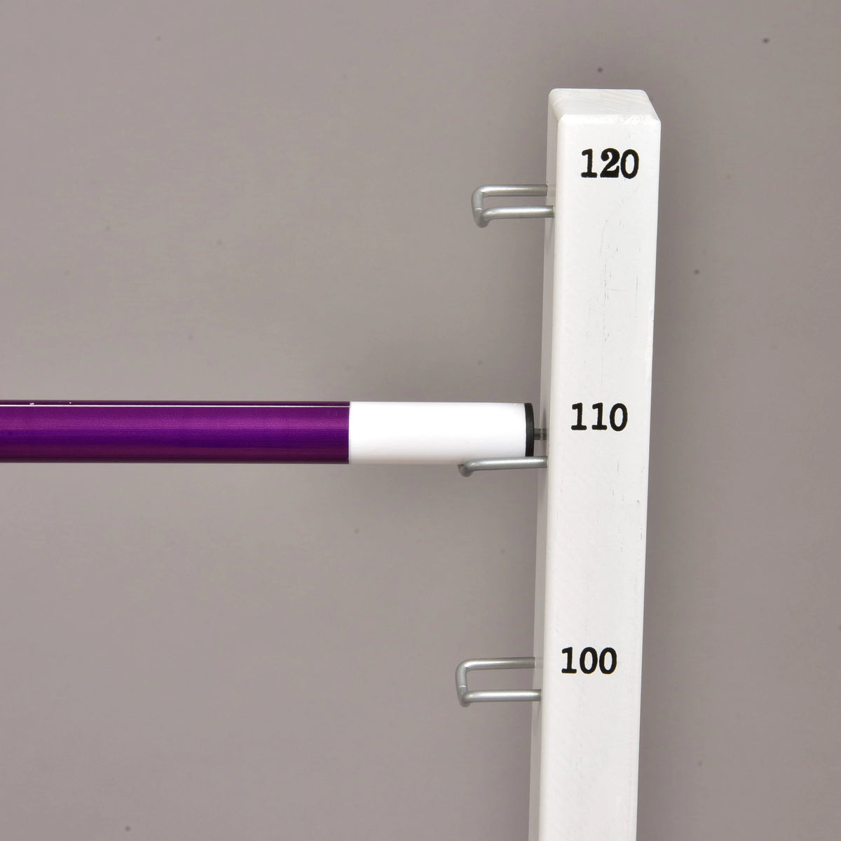 Fehér végű lila akadályrúd egy magas fehér oszlop 110 cm-es fém tartókampóján