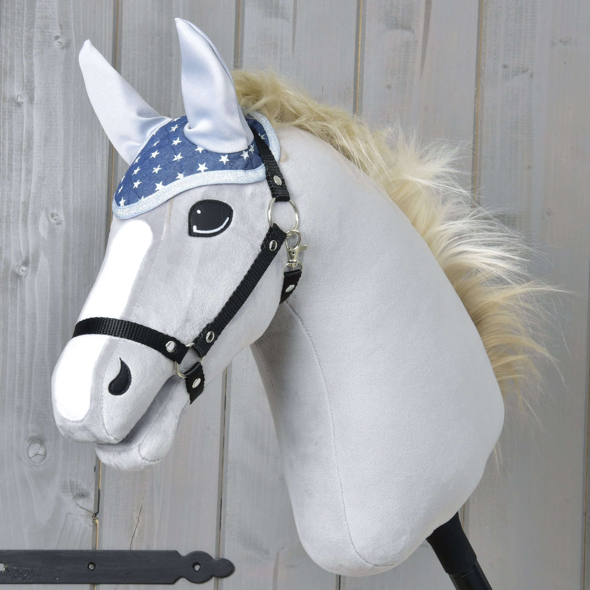 Szőke sörényű, szürke Hobby Horse ló fekete kötőfékben, a kék, fehér csillagos Star fülvédővel és ezüst fülekkel