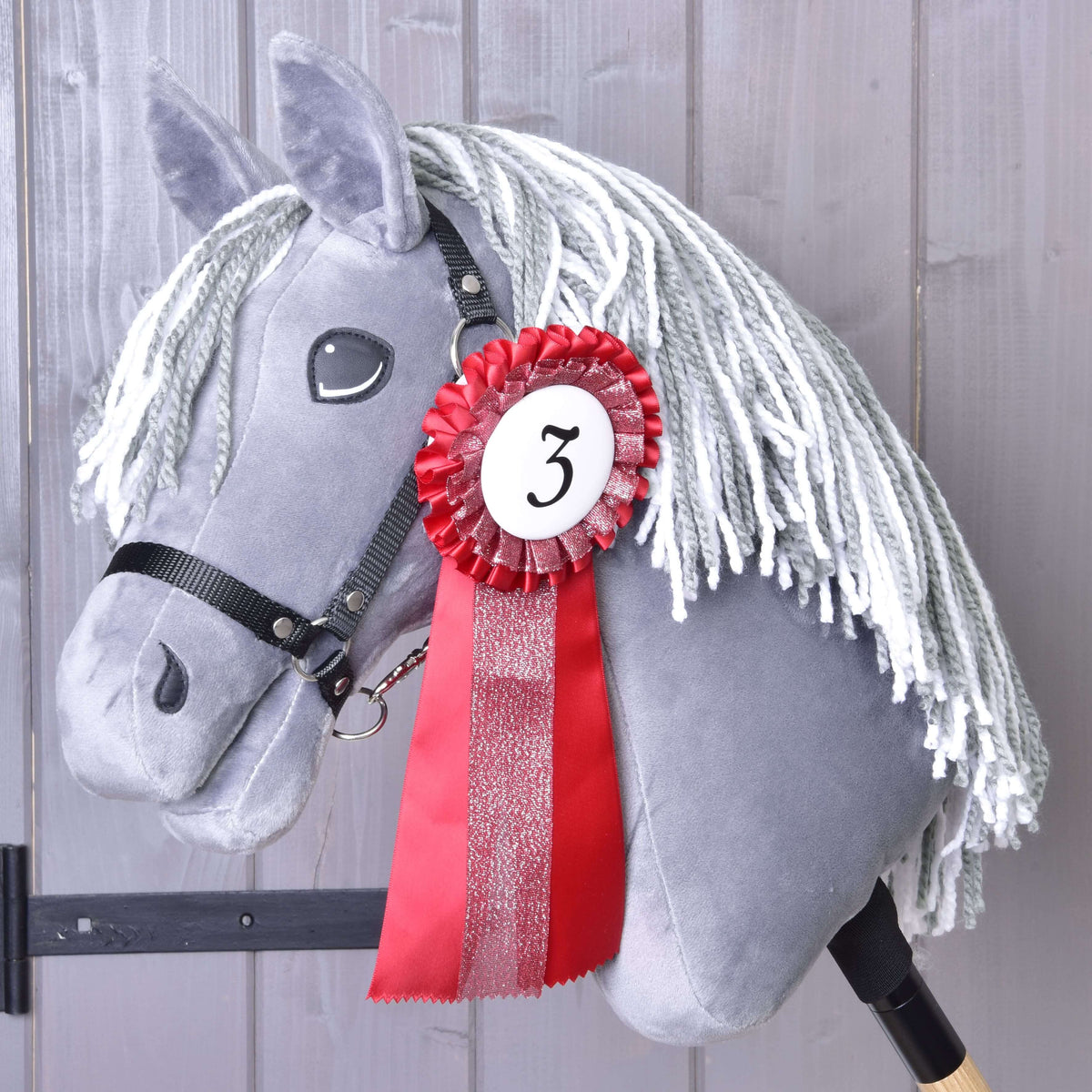 Third place: the red rosette with number 3 and a glittering tail on the neck of a grey Hobby Horse