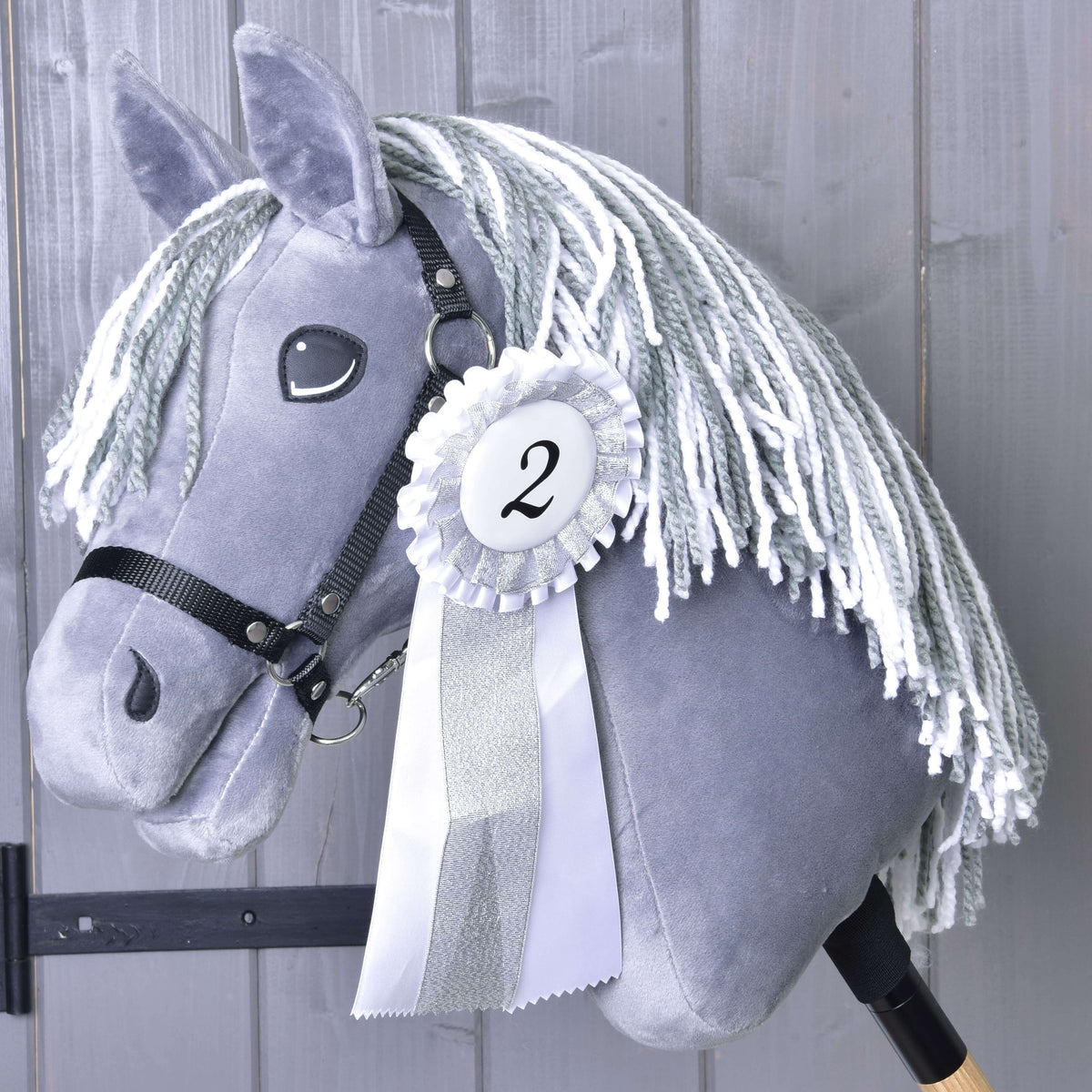 Second place: the white and silver rosette with number 2 on a grey Hobby Horse with a grey and white yarn mane