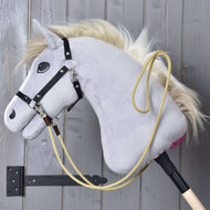 Szürke Hobby Horse ló fekete kötőfékben, a homokszínű Dakota western kantárszár bekapcsolva és a nyakára vetve