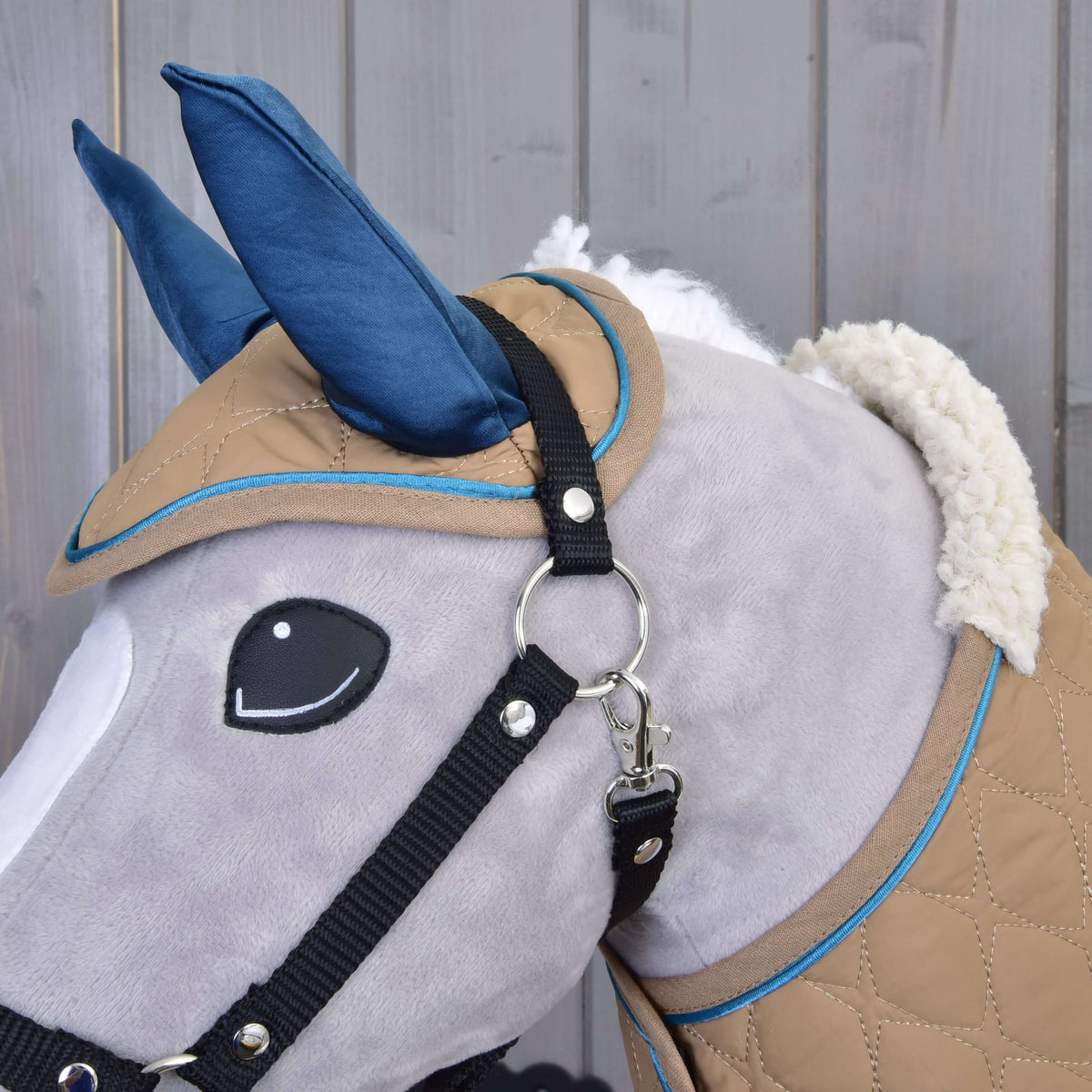 Grey Hobby Horse head in close-up with the Almond Star ear bonnet, black halter and the blanket's fluffy sherpa collar