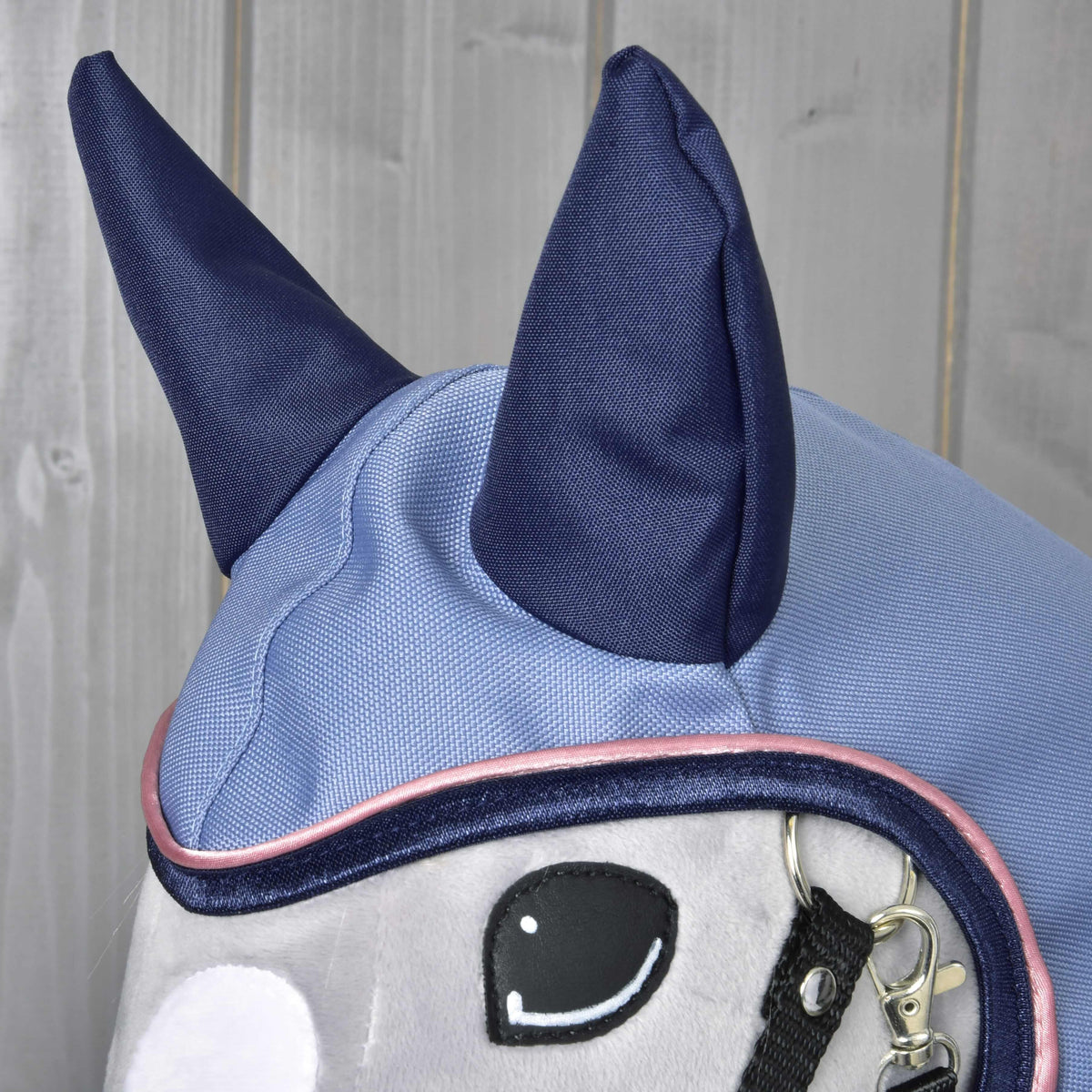 A Hobby Horse Bloom esőtakaró kapucnija közelről: sötétkék fülek a világoskék anyagon és rózsaszín paszpól az arcnyílás körül