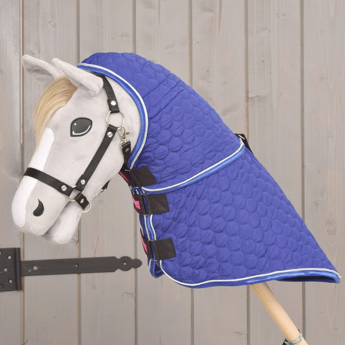 Grey Hobby Horse in left profile covered in royal blue from ears to stick by the Bluebell blanket and neck cover