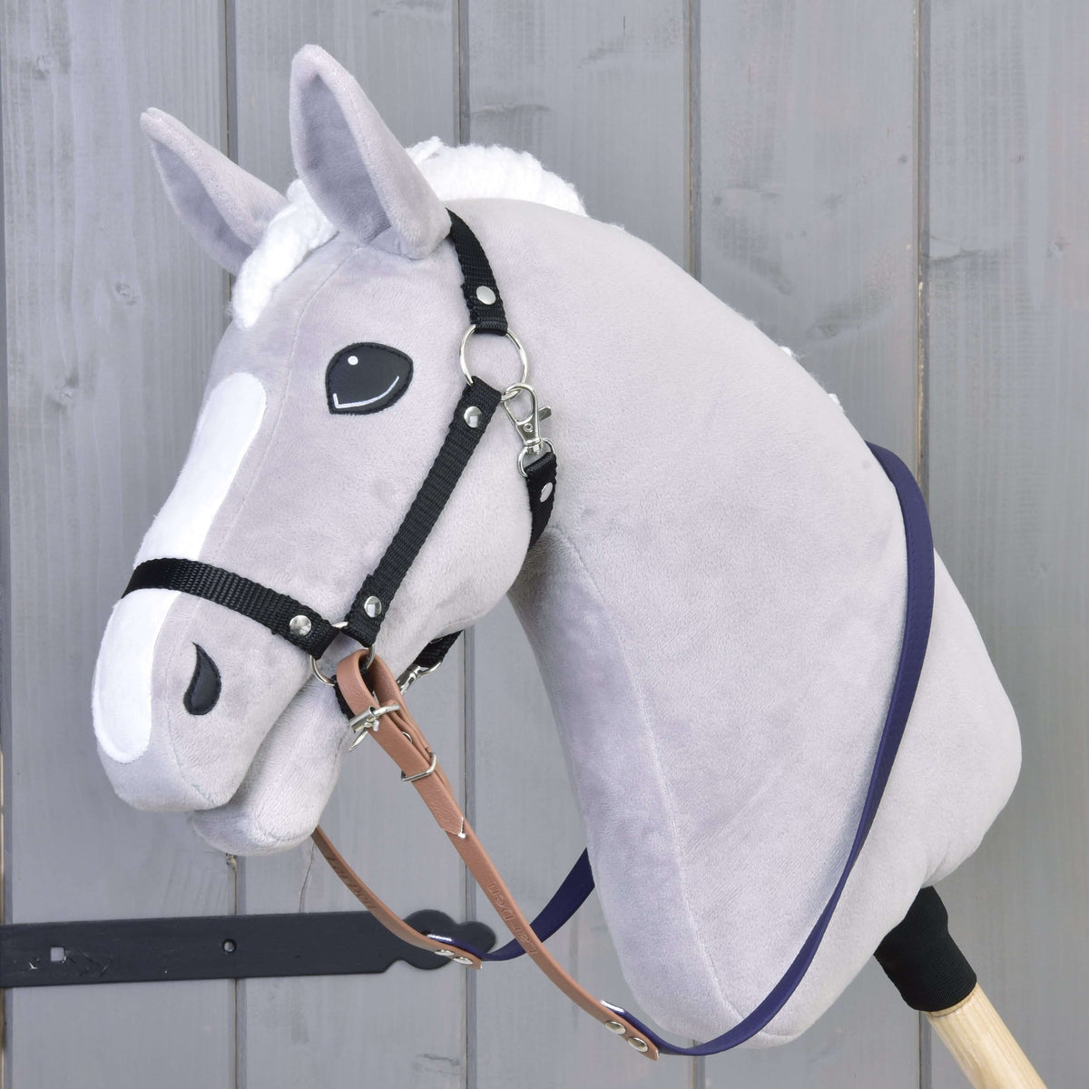 Szürke plüss Hobby Horse ló fekete kötőfékkel, a nyaka mentén barna-sötétlila gumírozott kantárszárral