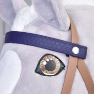 A sötétlila méhsejtmintás homlokszíj közelről ezüst szegeccsel egy szürke Hobby Horse ló barna szeme fölött