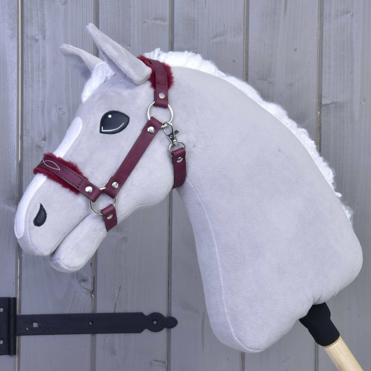 Fehér sörényű világosszürke Hobby Horse ló a bordó műbőr kötőfékben, szőrmével az orrszíjon és a tarkószíjon