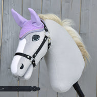 Világosszürke Hobby Horse ló fekete kötőfékkel és krémszínű sörénnyel, a lila horgolt fülvédőben