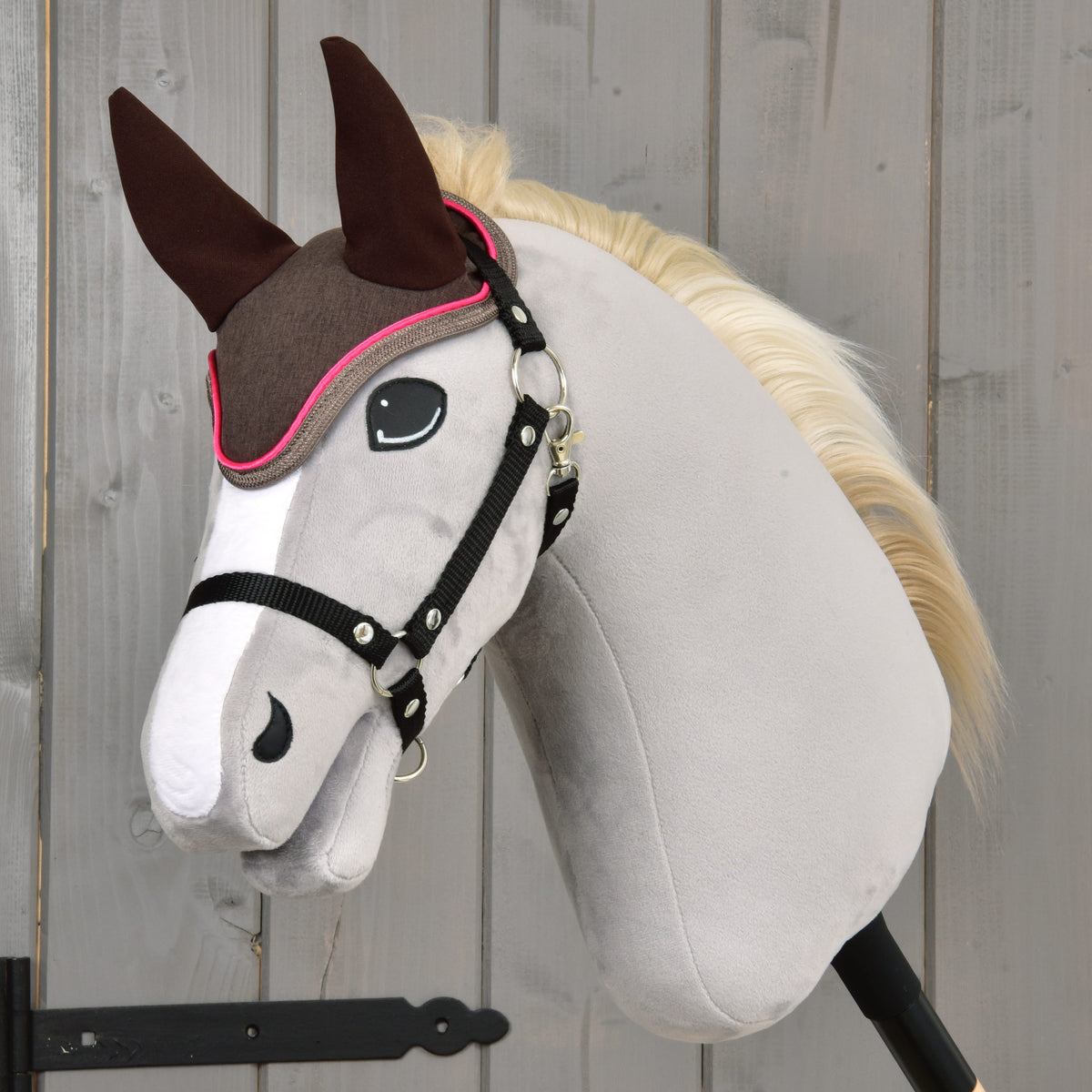 Grey Hobby Horse with a cream mane and black halter wearing the brown Rosewood ear bonnet with bright pink piping