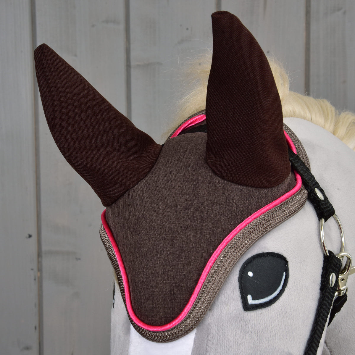 Close-up of the Rosewood ear bonnet on a grey head, with dark brown ears, a brown melange front and bright pink piping