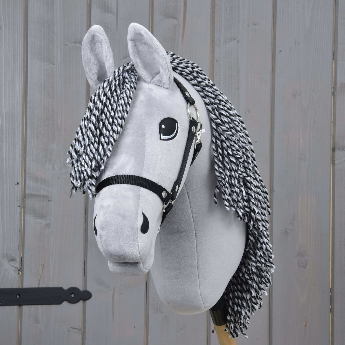 Front view of Hobby Horse Caesar with a black and white yarn forelock, black eyes and a black halter