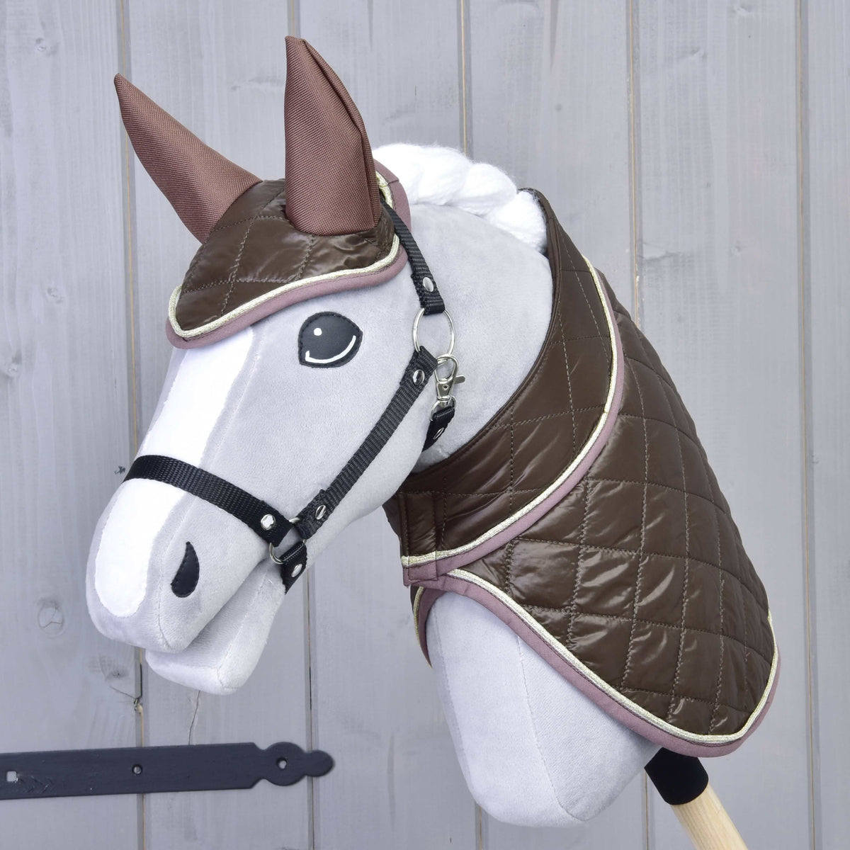 Szürke Hobby Horse ló fekete kötőfékkel, rajta a Thermo Chocolate szett: fényes barna steppelt takaró és fülvédő