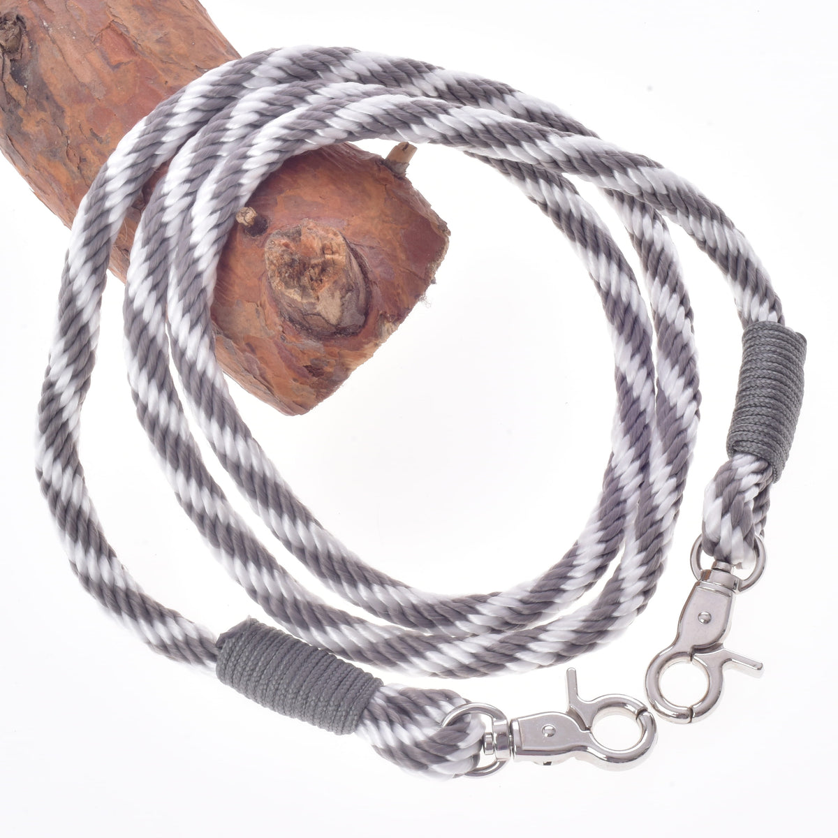 Reins from the Set Start Silver in grey and white twisted rope with a snap hook at each end, coiled over a branch