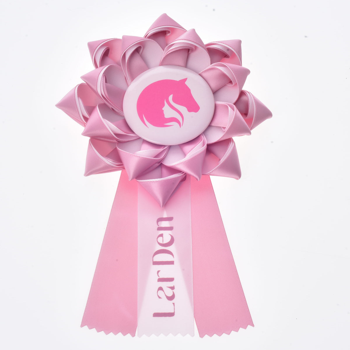 Hobby Horse rozetta LarDen Pink: világos rózsaszín szaténrozetta rózsaszín lófejjel egy fehér jelvényen és három cikcakkos szalagvéggel