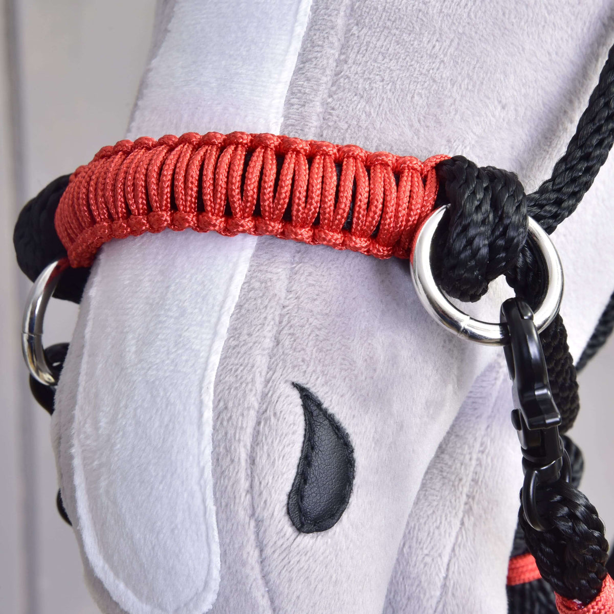 A Hobby Horse Spark kötélszett kötőfékének piros fonott orrszíja közelről, ezüstszínű karikákkal