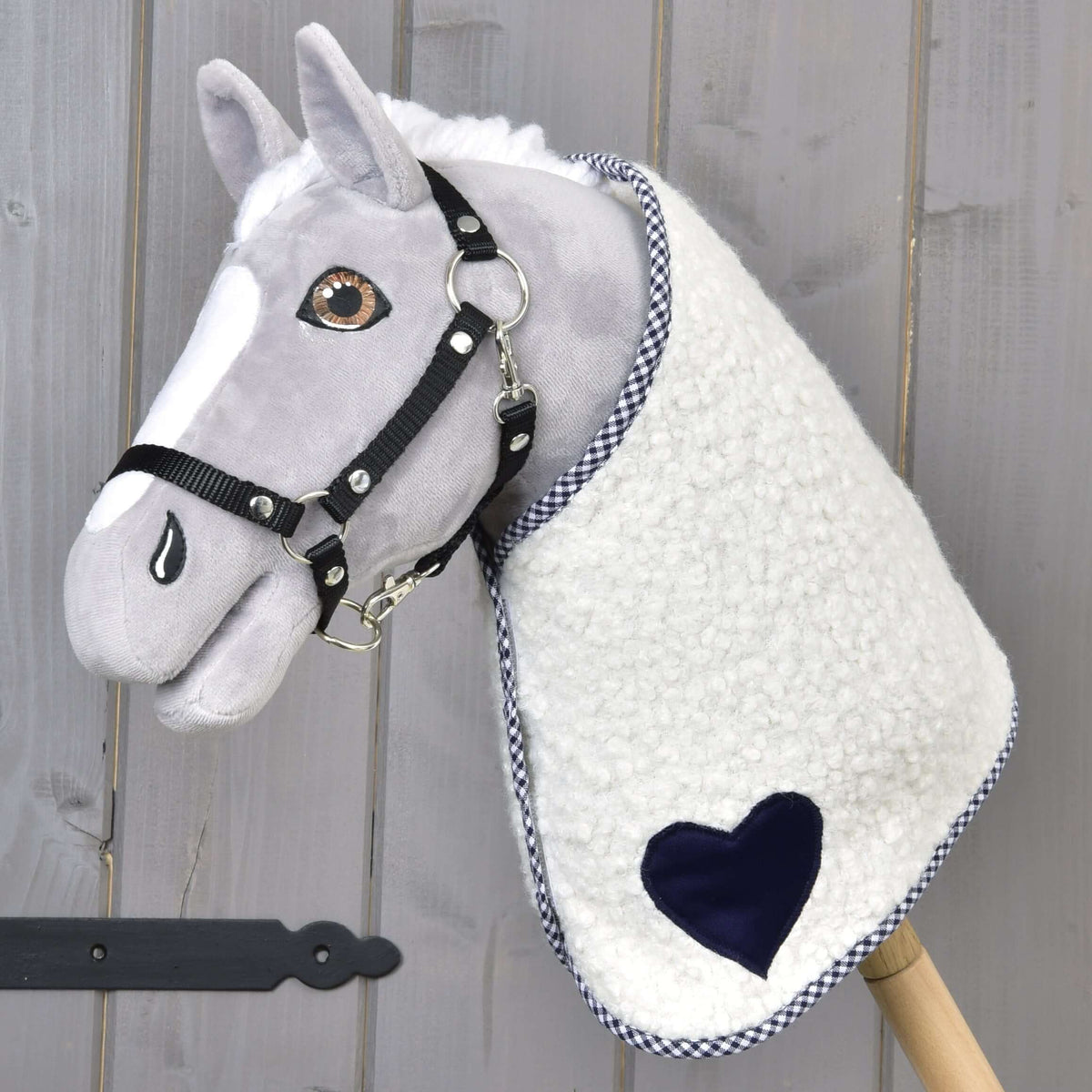 Light grey Hobby Horse in a black halter wearing the Blanket cube blue with navy heart and checked trim