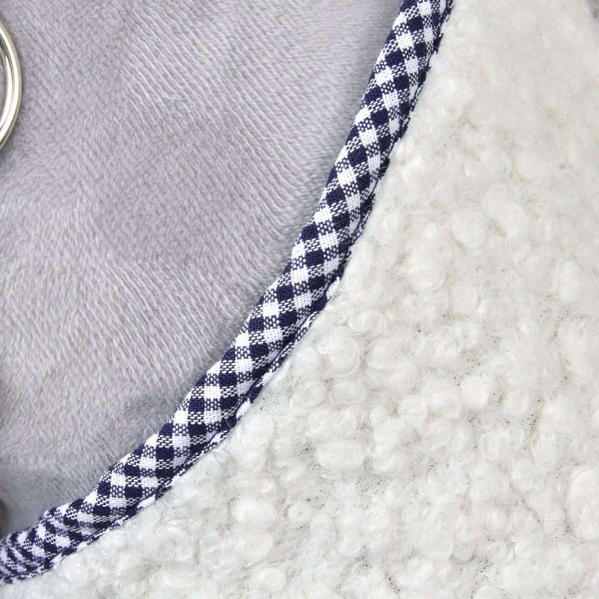 Close-up of the Hobby Horse Blanket cube blue neckline with navy and white gingham piping on cream curly fleece
