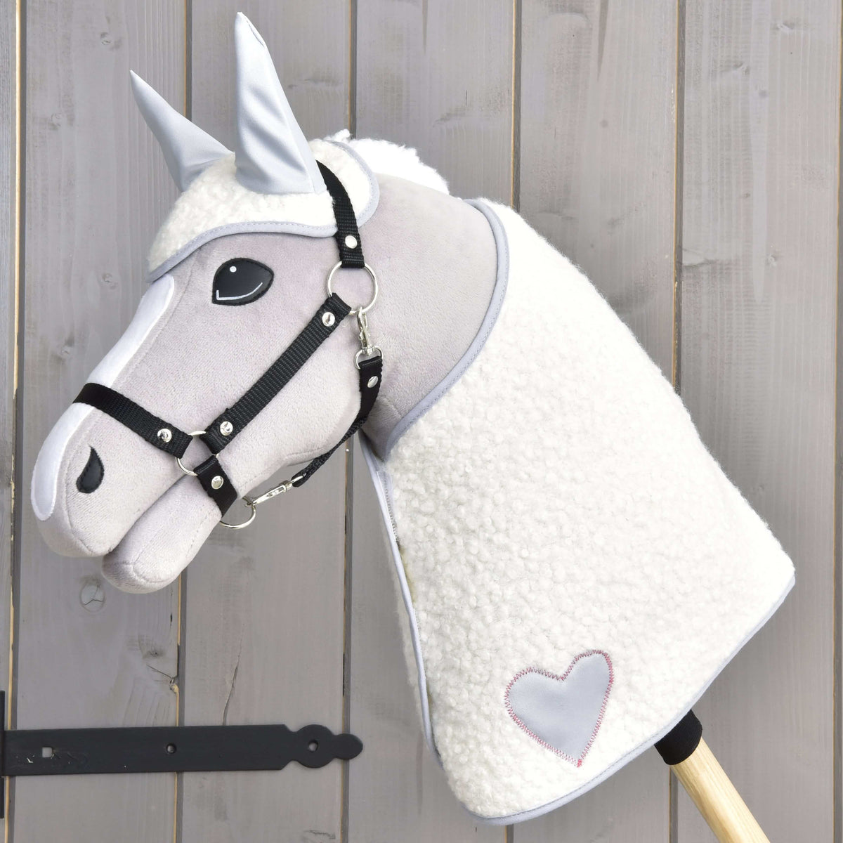 Szürke Hobby Horse ló fekete kötőfékben, rajta a Snowflake szett: krémszínű polártakaró szürke szívvel és hozzáillő fülvédő