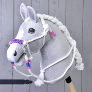 Szürke plüss Hobby Horse ló, rajta a fehér csomózott kötőfék rózsaszín-kék fonott orrszíjjal és a hozzáillő fehér kantárszár