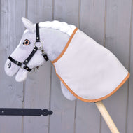 A grey plush Hobby Horse in a black halter wears the blanket turned to its plain light side with caramel trim