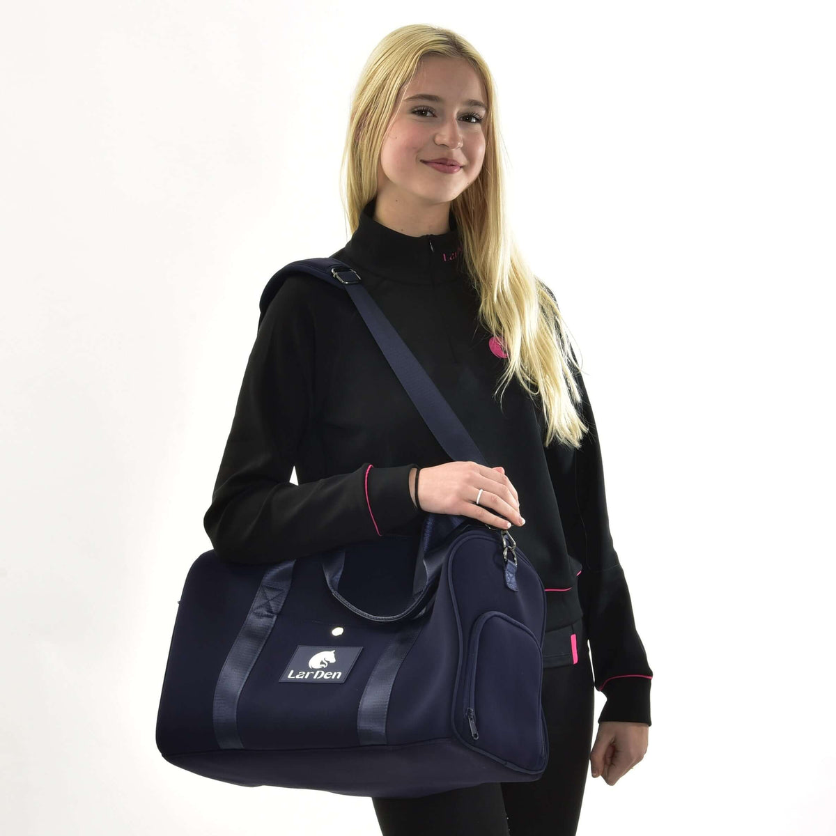 Szőke lány fekete pulóverben, a vállán fehér LarDen logós sötétkék Hobby Horse sporttáskával