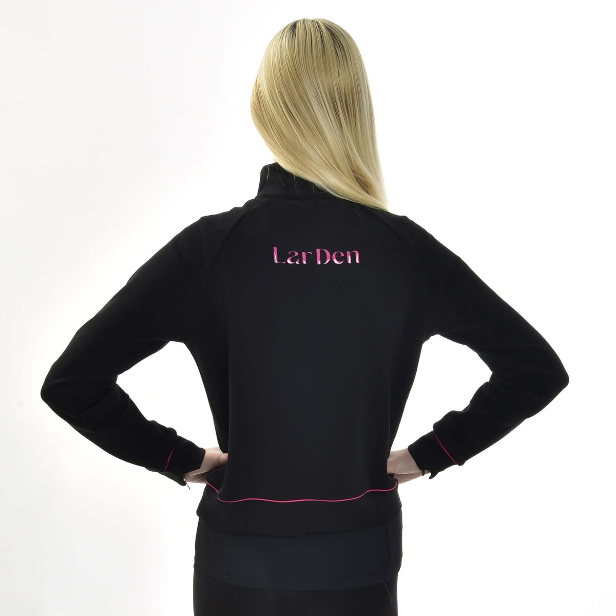 Blonde girl seen from behind, hands on hips, in the black Hobby Horse LarDen Sweatshirt with pink back lettering