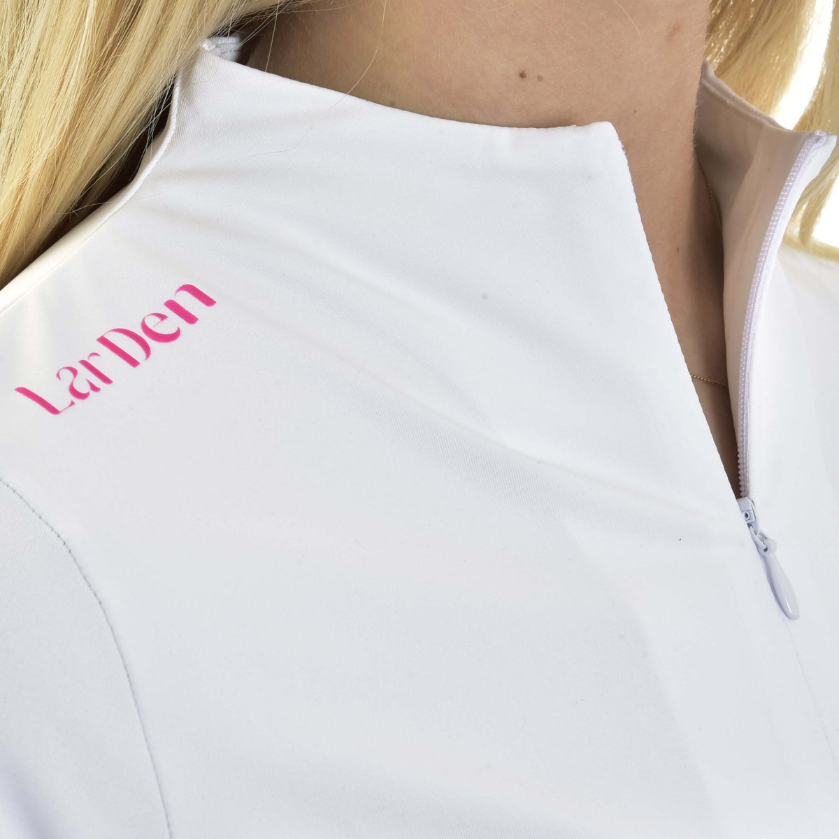 Close-up of pink LarDen lettering beside the white zipped collar of the Hobby Horse T-Shirt Premium