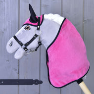 Barna szemű szürke Hobby Horse ló fekete kötőfékben, rajta az élénk rózsaszín bársonyos takaró és fülvédő