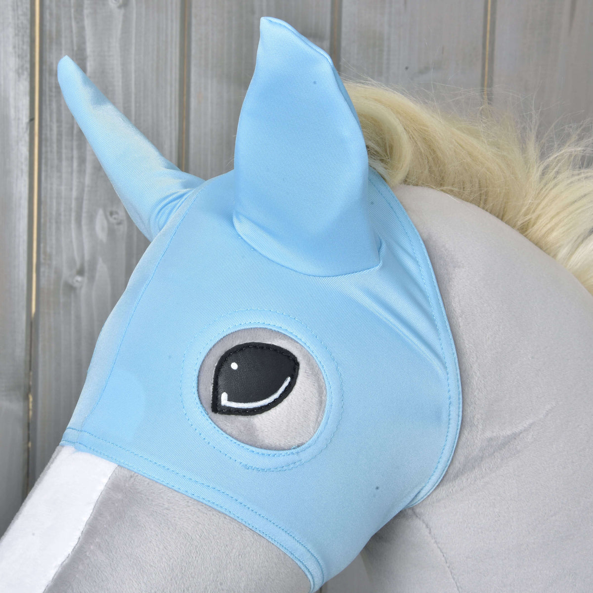 Close-up of the Horse Mask Sky: light blue stretch fabric with pointed ears and a stitched round eye opening