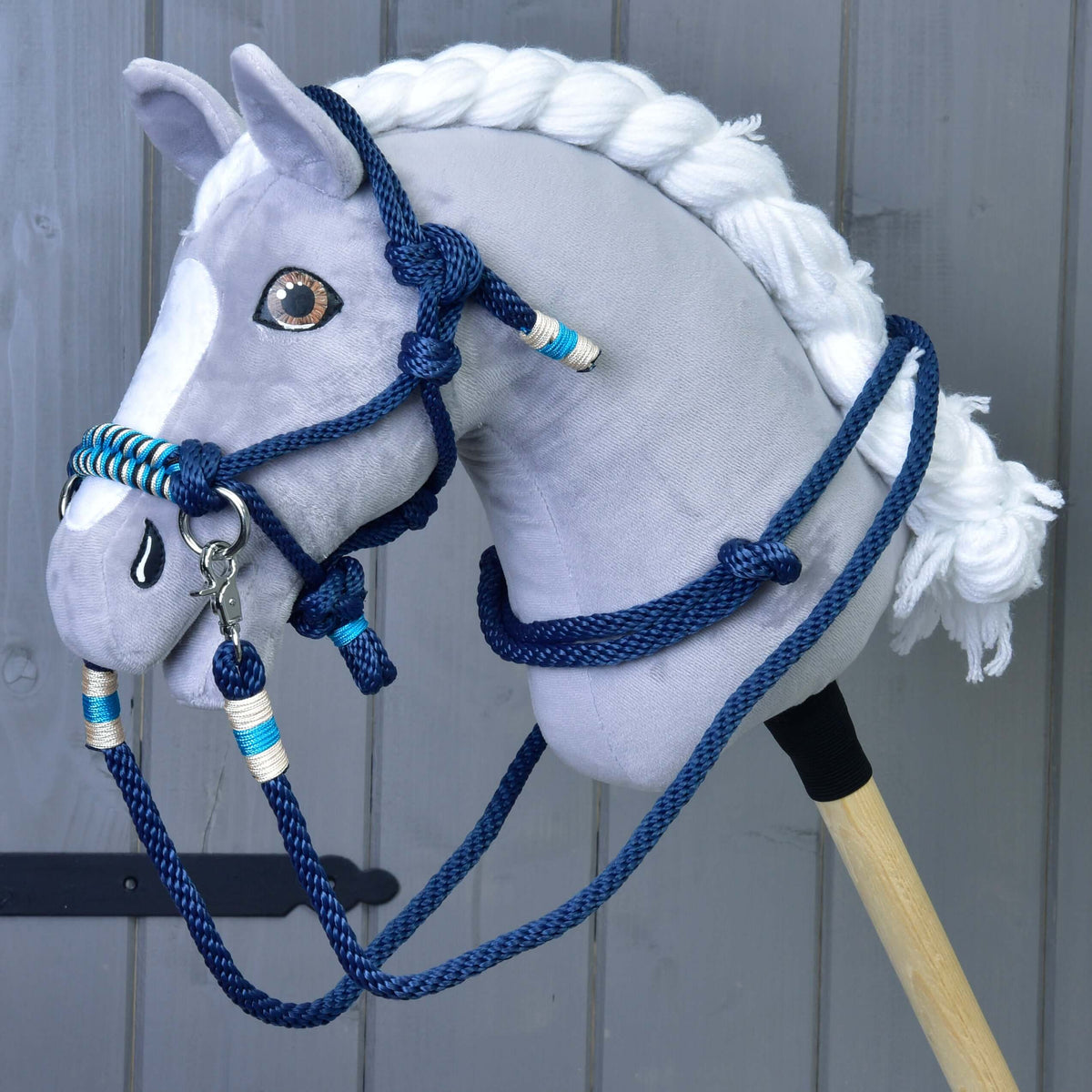 A grey plush Hobby Horse wears the Rope set navy: navy rope halter and reins with turquoise and cream accents