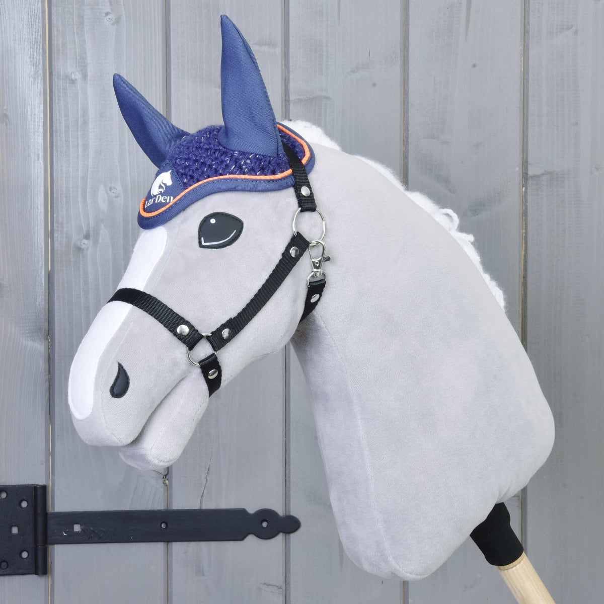 Fehér hókás szürke plüss Hobby Horse ló fekete kötőfékkel és a sötétkék, narancssárga paszpólos horgolt fülvédővel