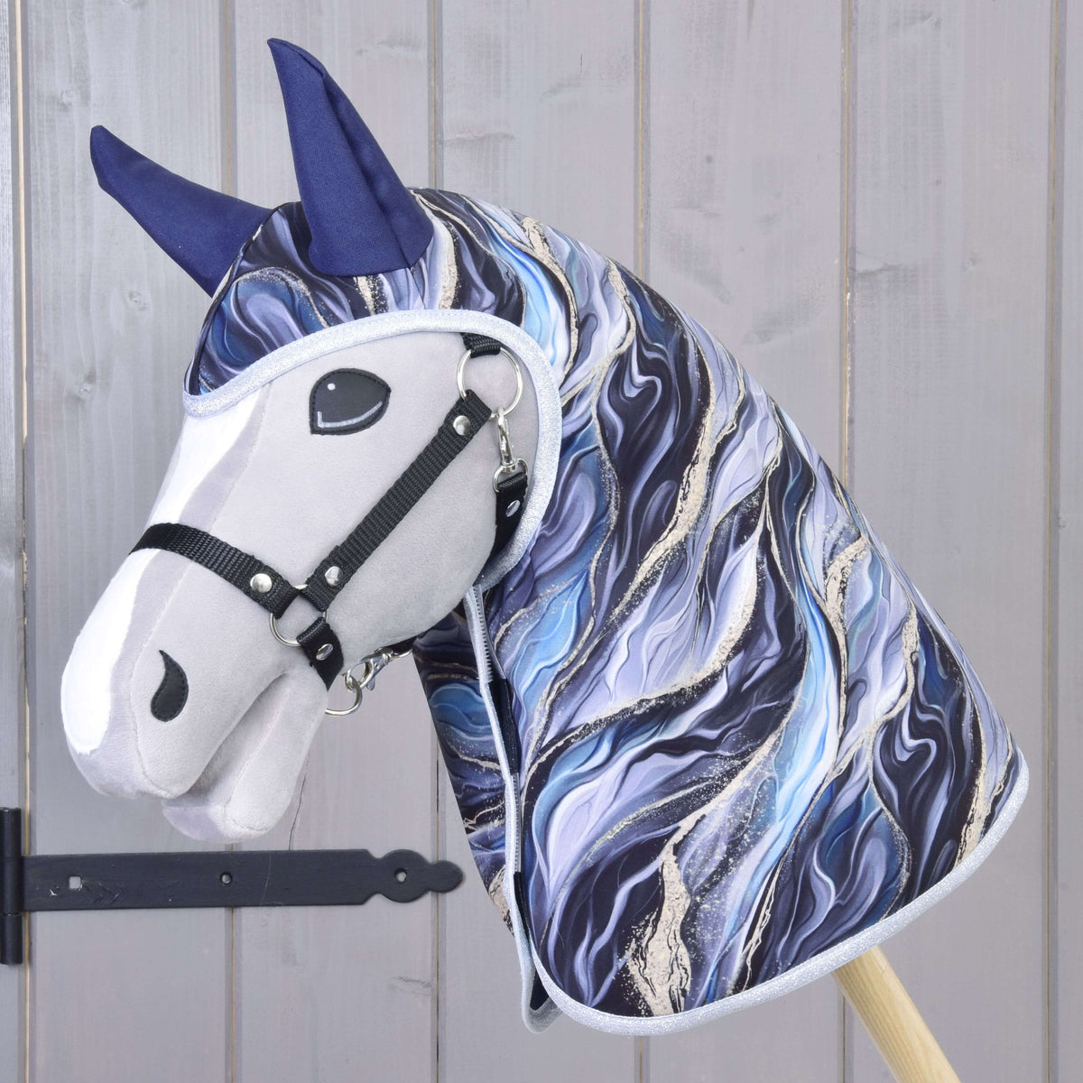 Grey Hobby Horse with black halter wearing the Raincoat Galaxy Cobalt, its blue marble print covering head and neck