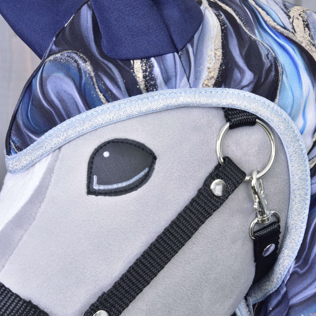 Close-up of the pale blue glitter edging around the face of a grey Hobby Horse in the Galaxy Cobalt raincoat, with navy ear