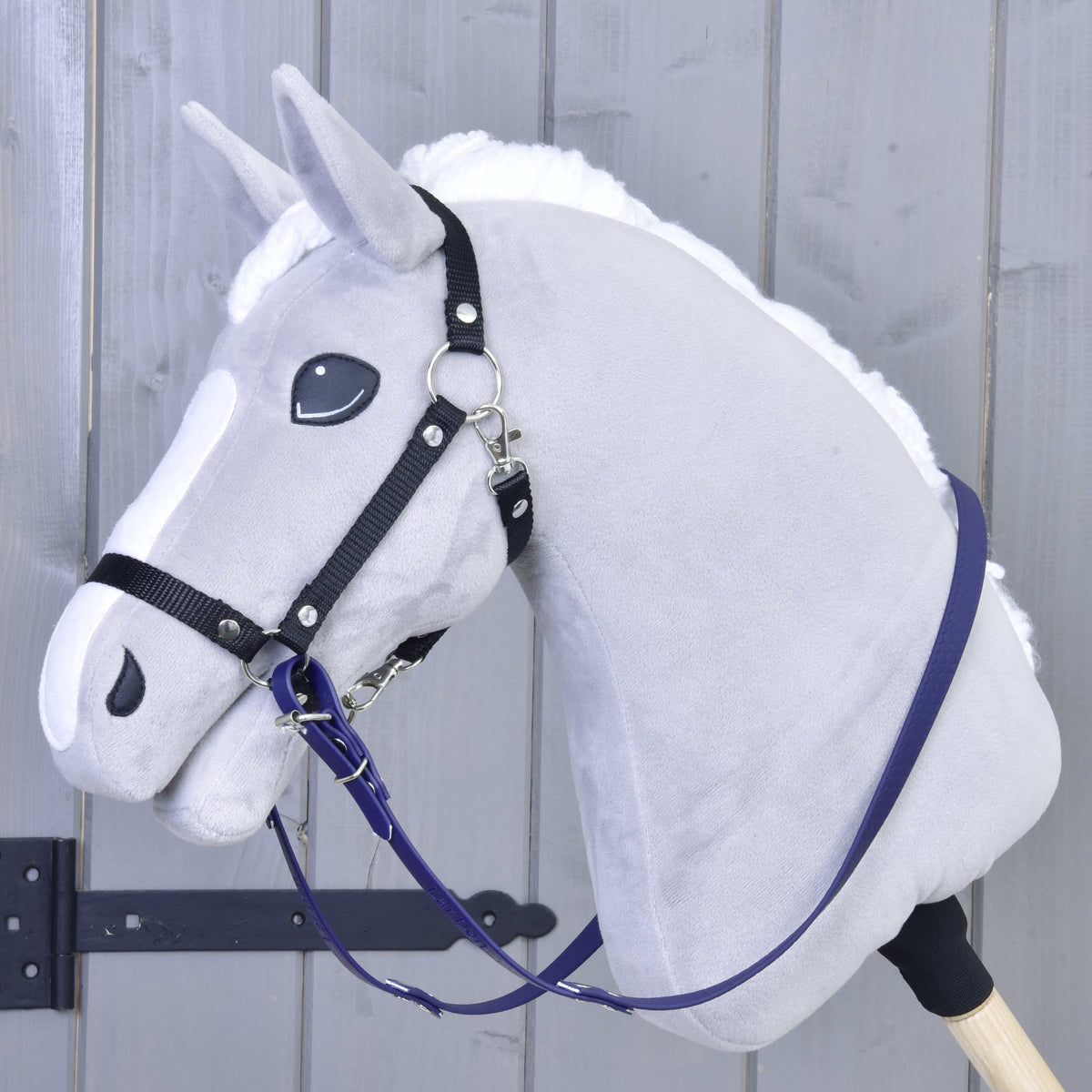 Szürke plüss Hobby Horse ló fekete kötőfékkel, a nyaka mentén lógó sötétlila gumírozott kantárszárral