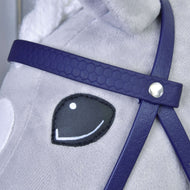 A sötétlila méhsejtmintás homlokszíj közelről ezüst szegeccsel egy szürke Hobby Horse ló mosolygó szeme mellett