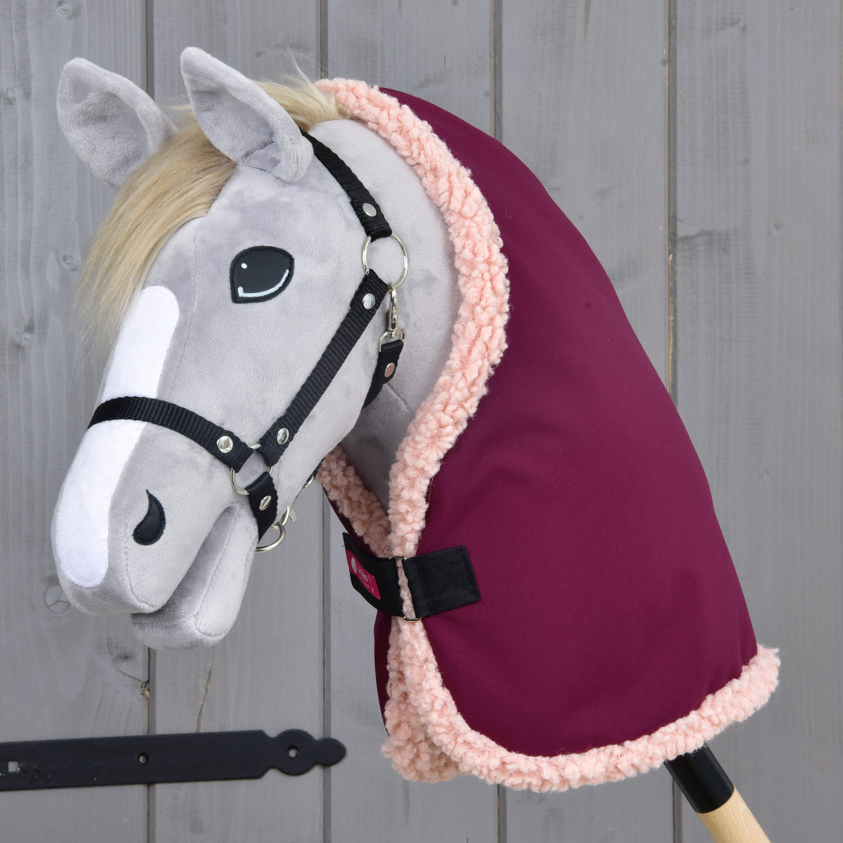 Grey Hobby Horse with a blond mane and black halter wearing the Stable Blanket Royal Burgundy with pale pink fleece edging