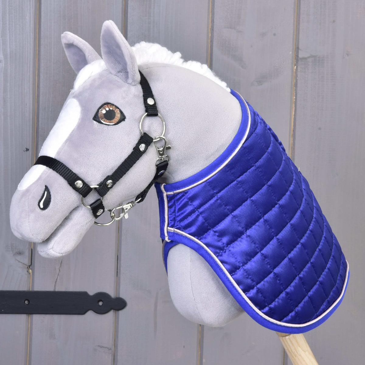 Borostyánszínű szemű szürke Hobby Horse ló fekete kötőfékkel, rajta a DeLuxe Blue takaró fényes királykék oldalával kifelé
