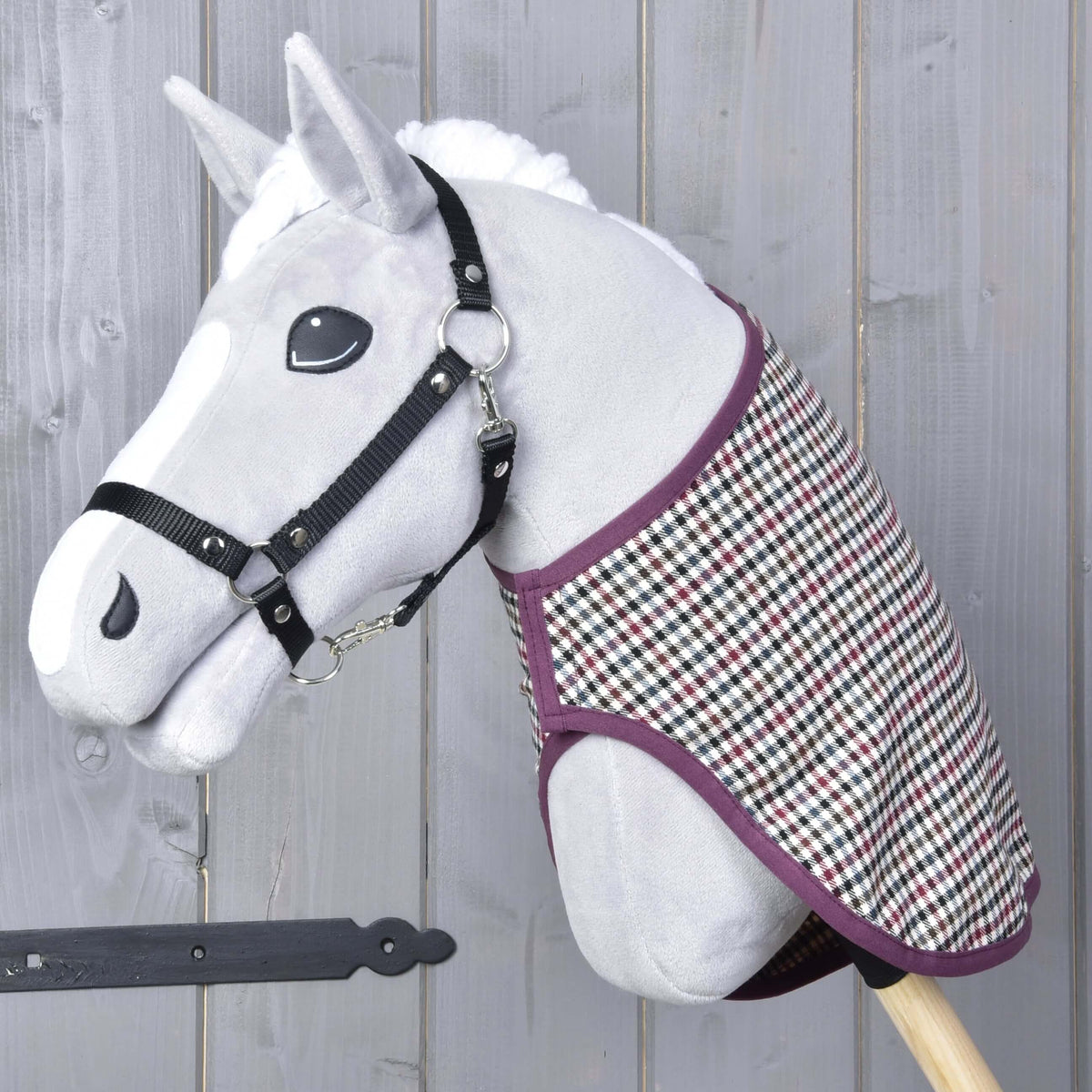 Szürke plüss Hobby Horse ló fekete kötőfékben, a nyakán a Colorado western takaró szilvaszínű szegéllyel