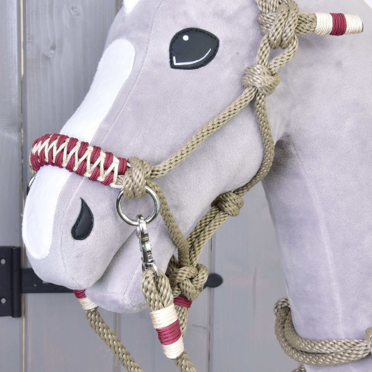 Close-up of the Hobby Horse Rope set Eleganza: burgundy and cream braided noseband, beige knots and a silver snap hook